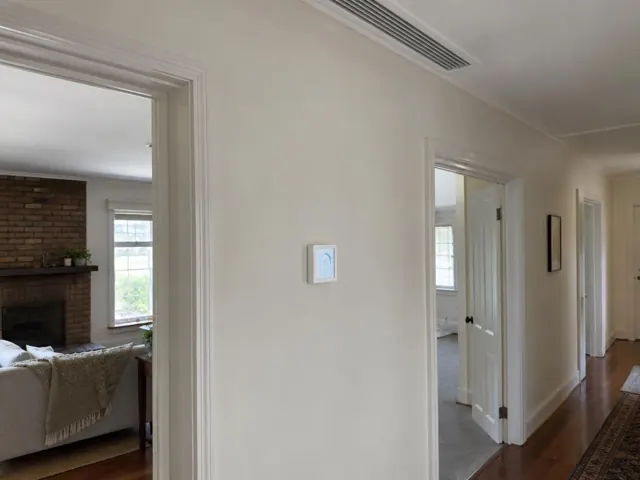 Hallway with ceiling ducted grille and wall controller in a cream interior hallway in Enfield